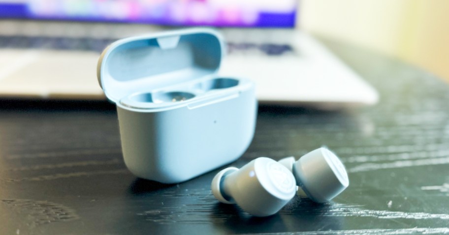 set of blue earbuds and their charging case on a desk