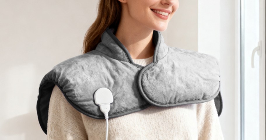 woman wearing grey heating pad on her shoulders