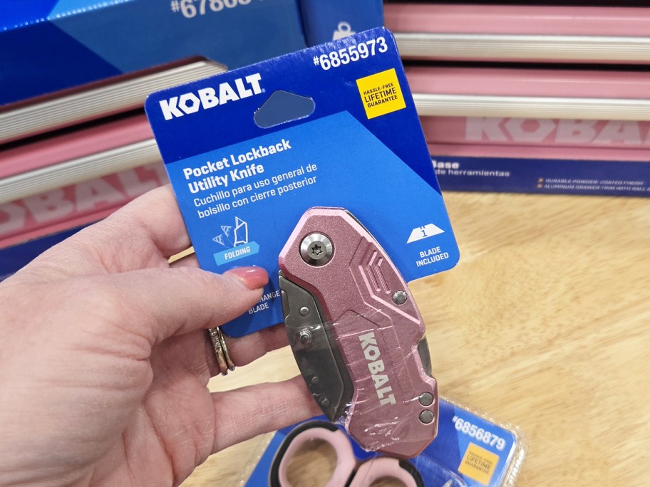 hand holding up a pink folding pocket knife