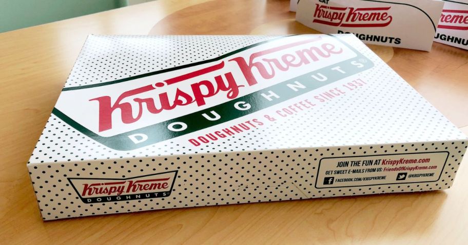A box with a dozen Krispy Kreme Doughnuts on a table