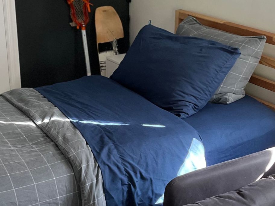 A bed with blue sheets and pillows on it