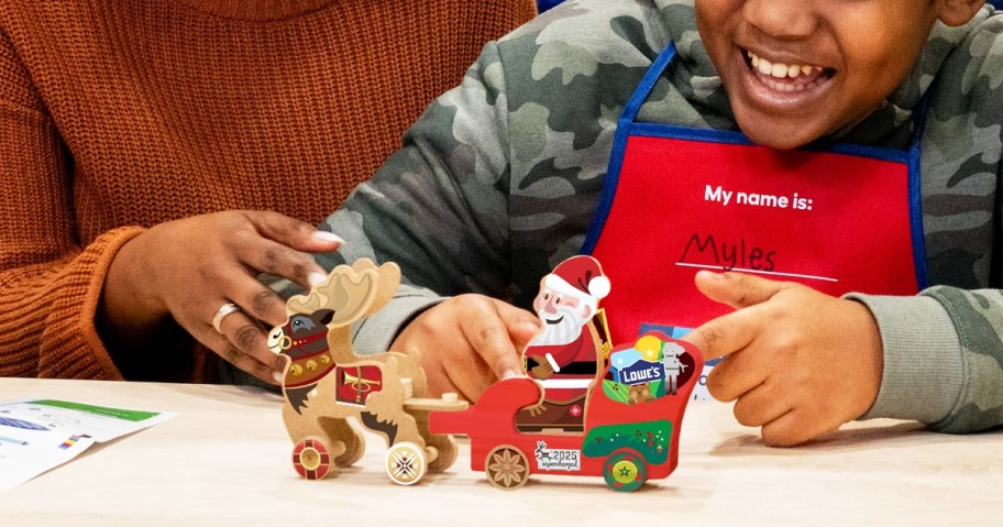 child building a wooden sleigh toy