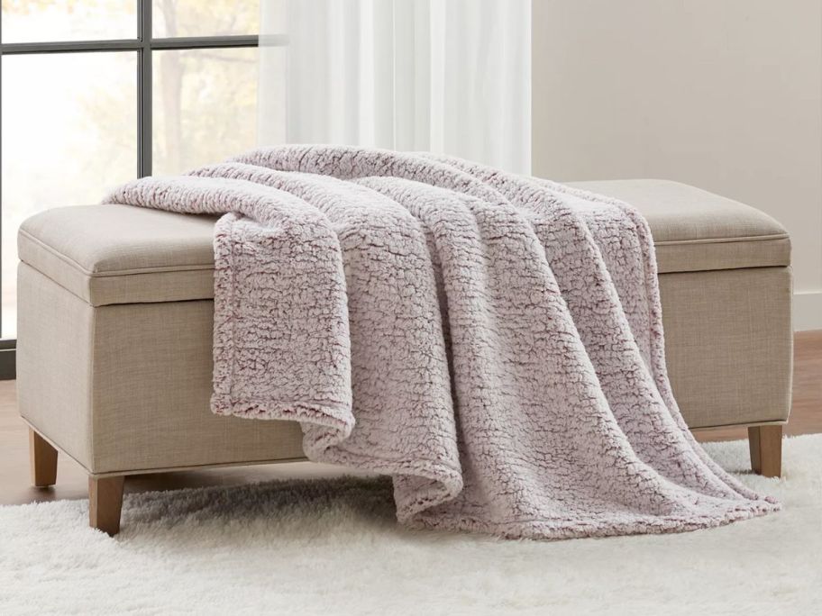 A tan throw blanket on a bench