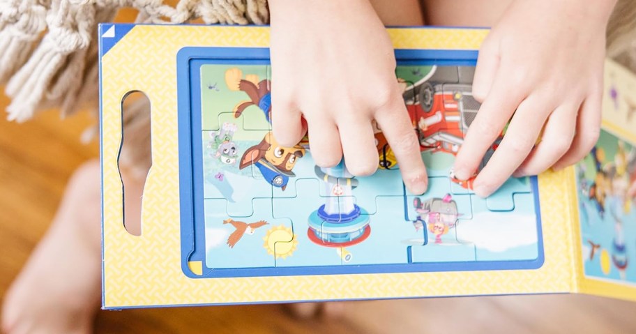 child placing last piece into a puzzle