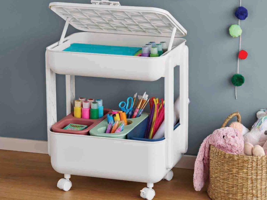 White kids craft station with wheels and storage bins filled with supplies