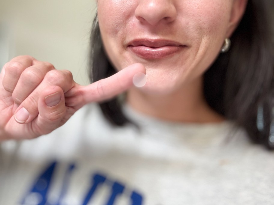 Woman holding pimple patch on her finger 