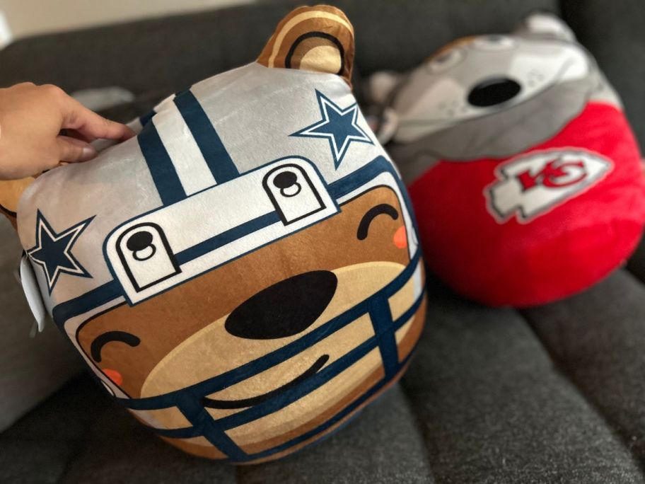 Hand touching a Dallas Cowboys Plush Bear Pillow