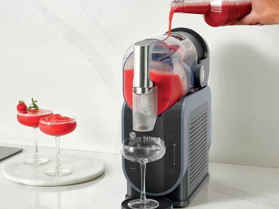 Ninja slushi with drink being poured inside of it