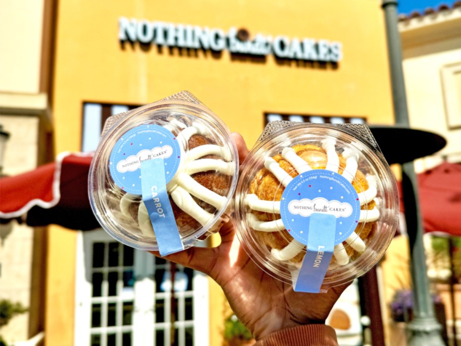 hand holding up two Nothing Bundt Cakes outside of store