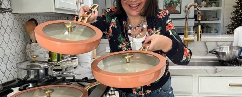 Woman holding pink Our Place pans with gold trimmed lids