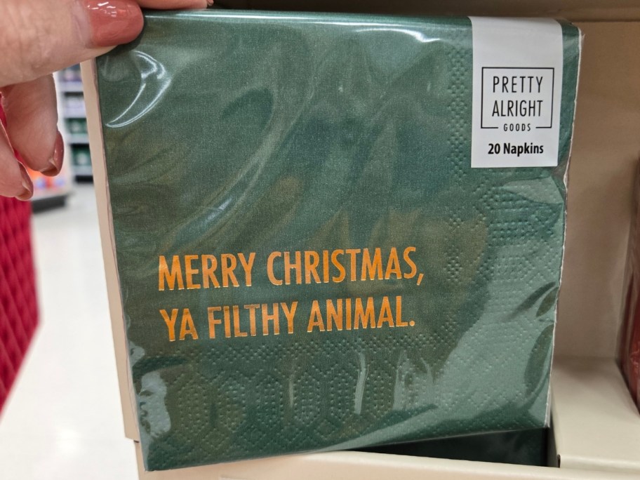 hand holding a pack of napkins that say 'Merry Christmas, Ya Filthy Animal' 
