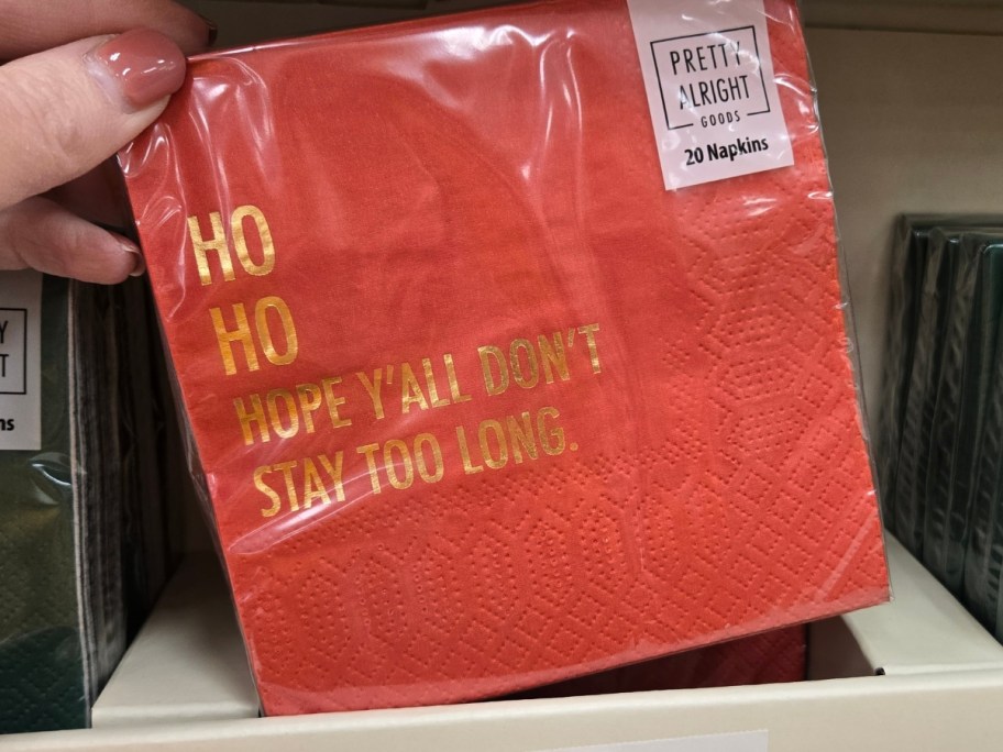hand holding a pack of napkins that says 'Ho Ho Hope You Don't Stay Too Long' 