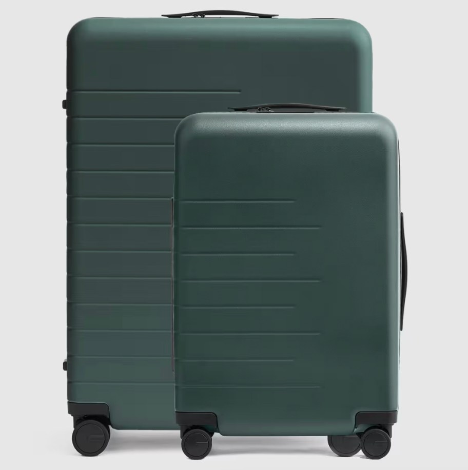 green hardshell suitcases on gray background
