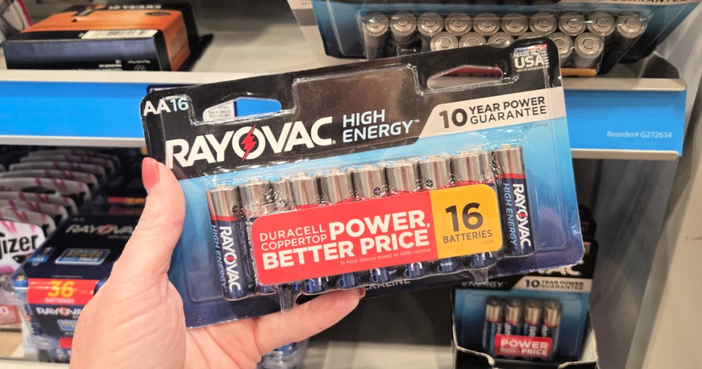 Person holding up 16 pack of Rayovac batteries inside Lowe's store