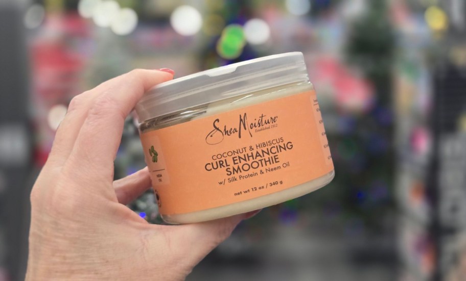 hand holding jar of SheaMoisture Smoothie Curl Enhancing Hair Cream Coconut & Hibiscus