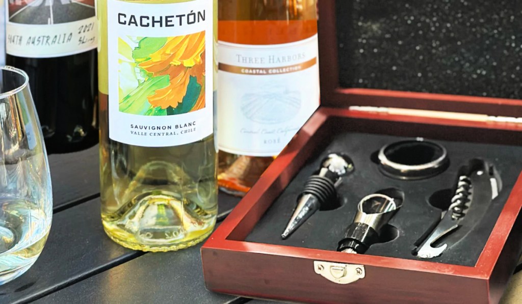 Two bottles of wine next to wooden wine kit