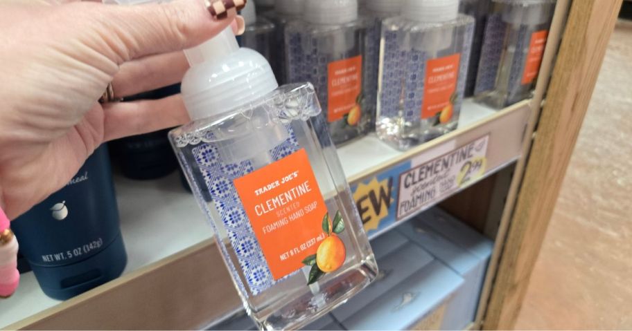 a person holding a bottle of hand soap