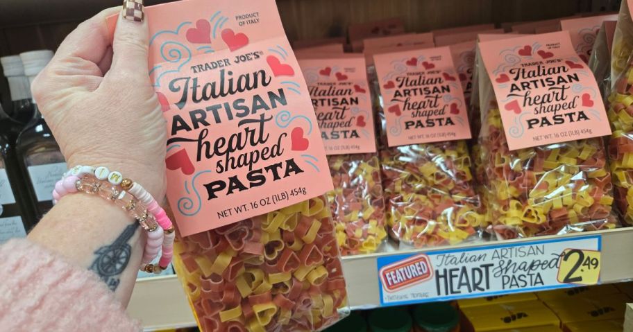 A person holding a bag of heart-shaped pasta