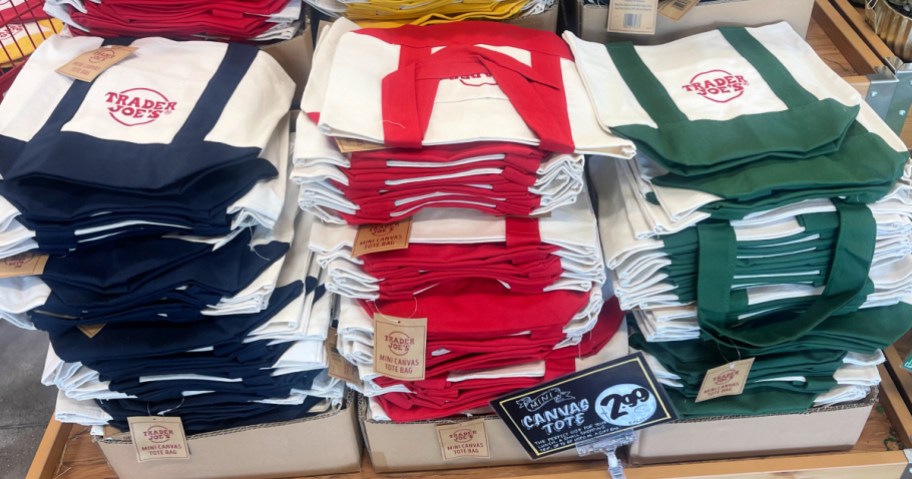 Blue red and green Trader Joe's totes on display in store