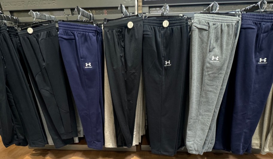 Under Armour pants hanging on rack in store