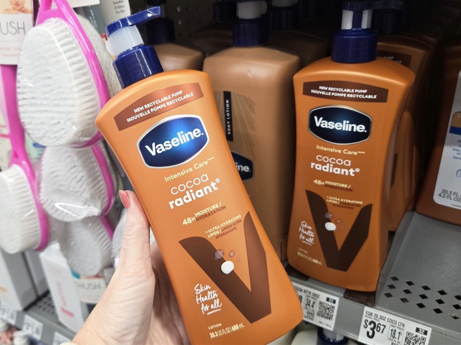 hand holding bottle of Vaseline Cocoa Radiant Body Lotion near store shelf