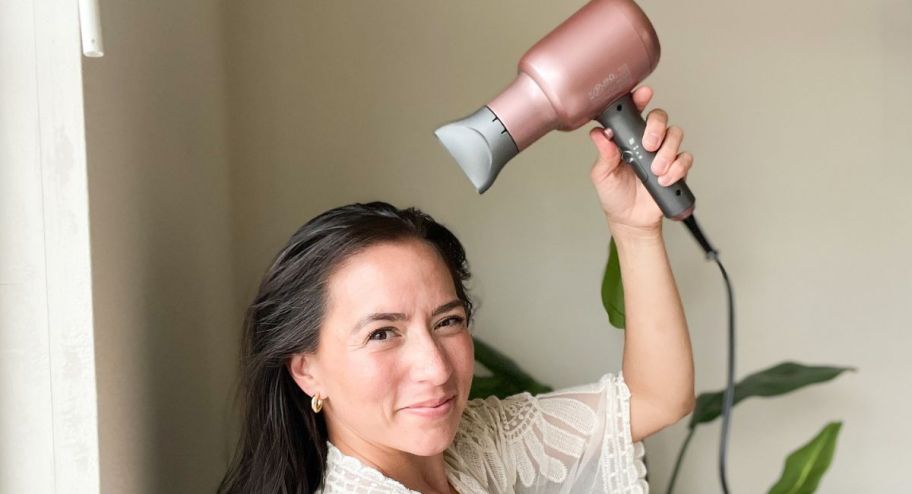 Hand holding the pink wavytalk hair dryer 