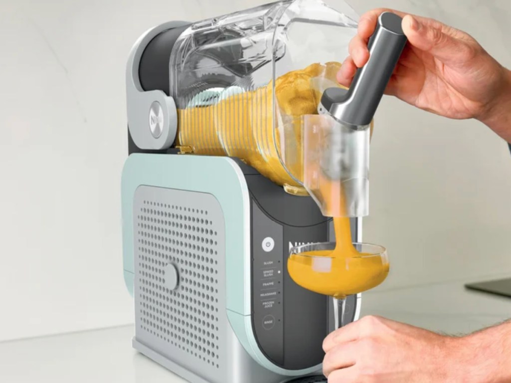 Extra large, ninja, slushi machine producing frozen orange drink