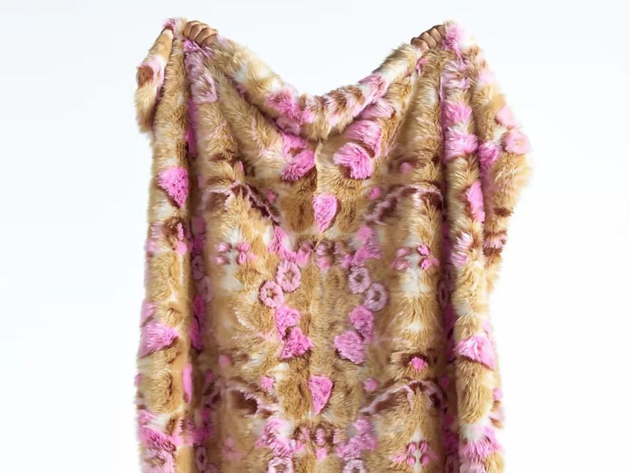 person holding Anthropologie Cordelia Jacquard Floral Faux Fur Throw Blanket