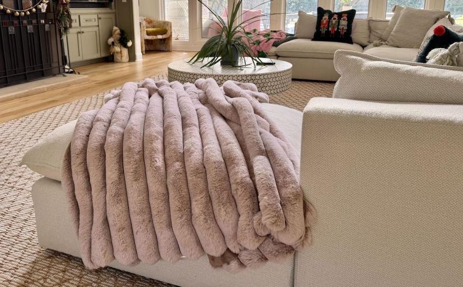 pink fluffy blanket on edge of sectional couch