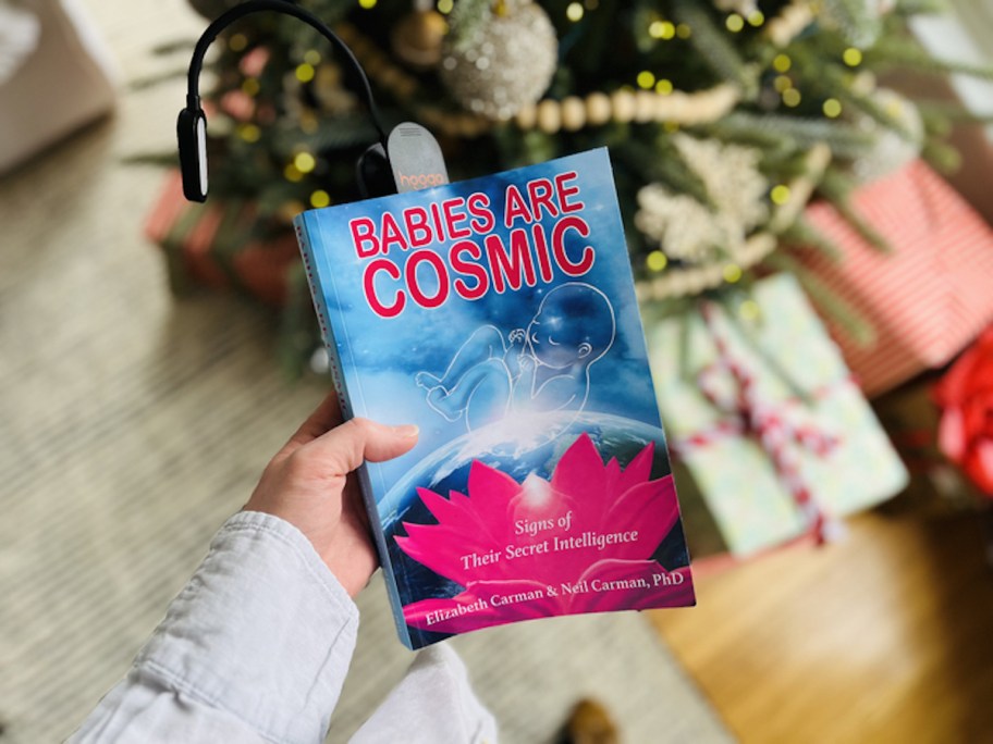 hand holding a babies are cosmic book