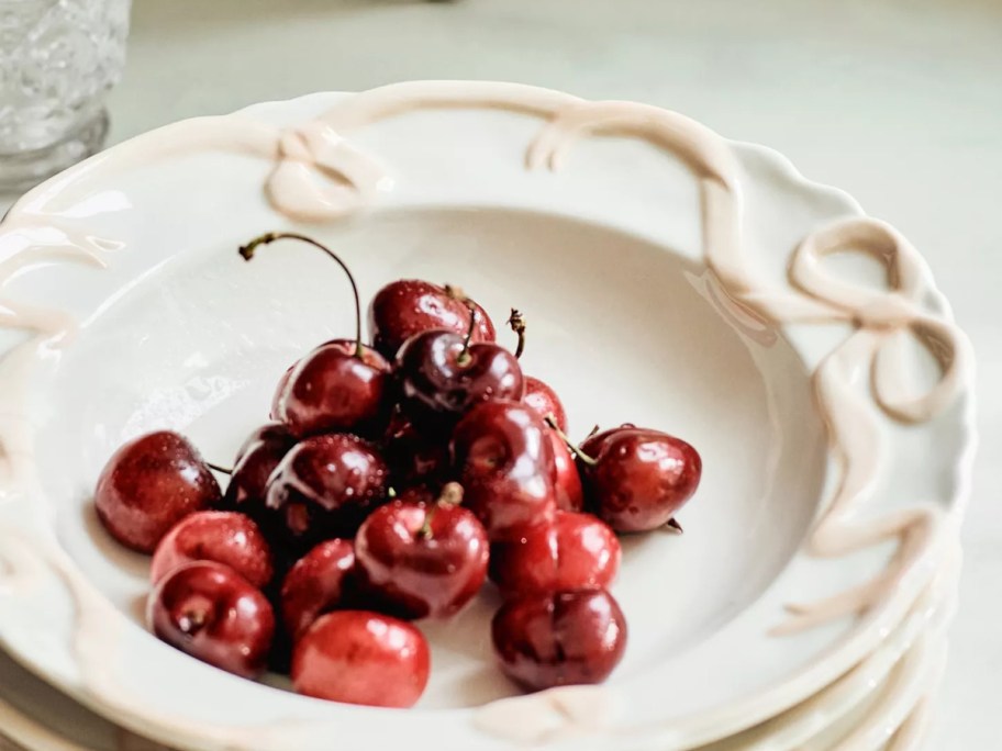 cherries in a bowl with bows on the side