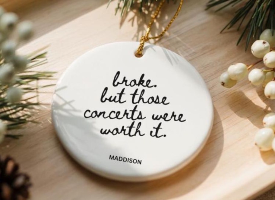 broke but those concerts were worth it circle ornament on wood table