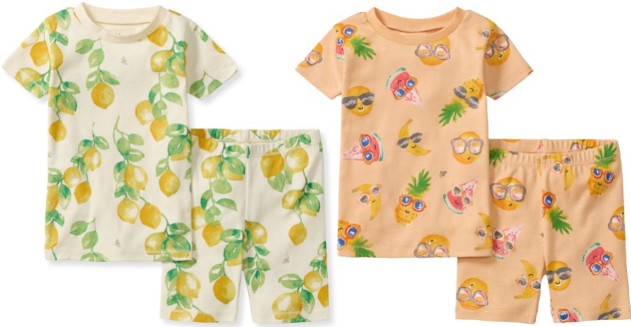 Two sets of short-sleeve and shorts pajamas, one off-white with a lemon print and the other peach featuring a pattern of various fruits wearing sunglasses, displayed against a white background.