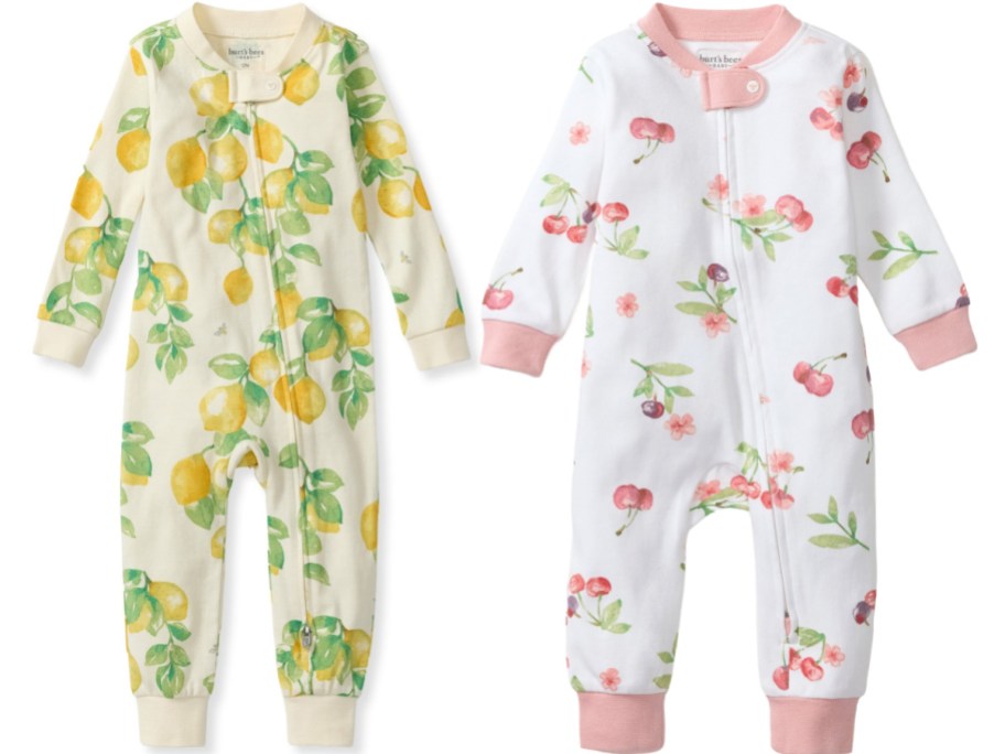 Two Burt's Bees Baby one-piece pajamas, one off-white with a lemon print and the other white with a cherry print, displayed against a white background.