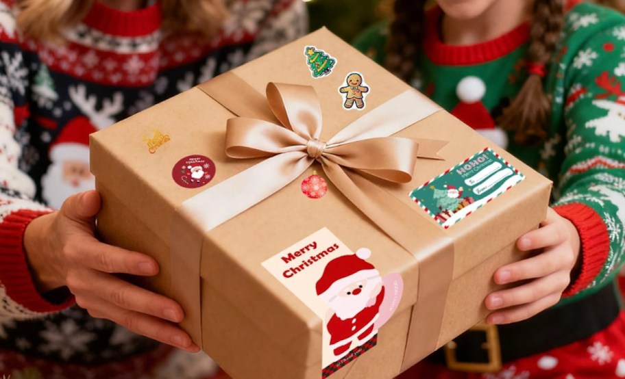 hand holding a present with christmas gift tags