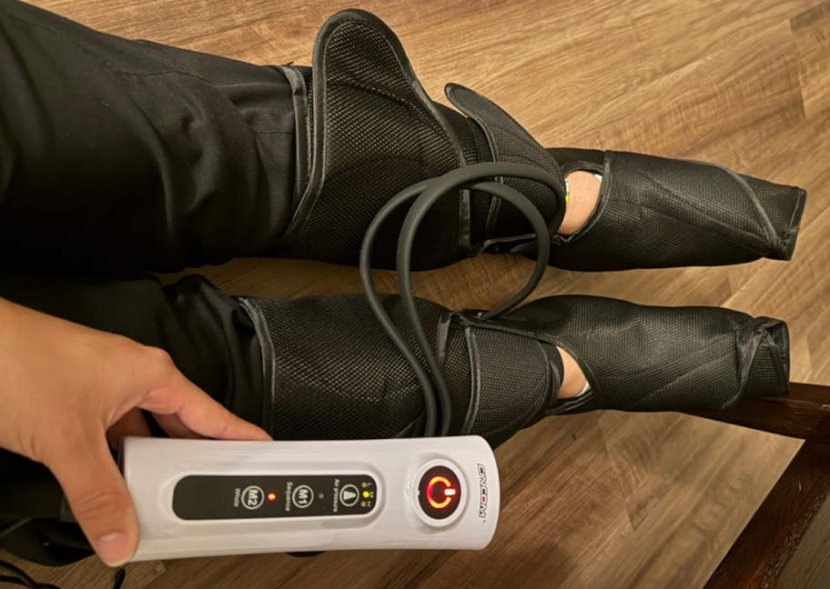 person wearing leg massager boots
