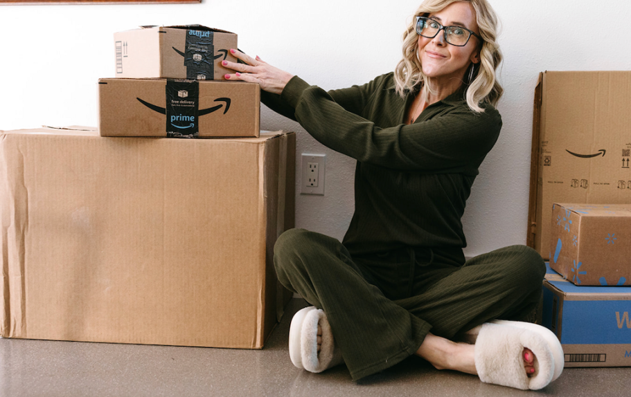 woman holding amazon box while sitting on floor