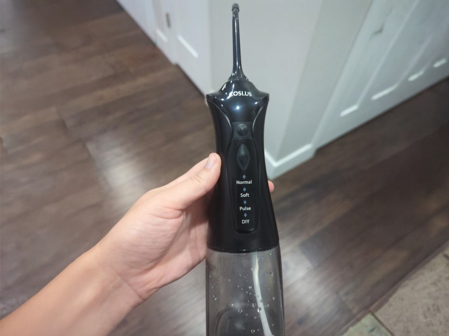 person holding a water flosser