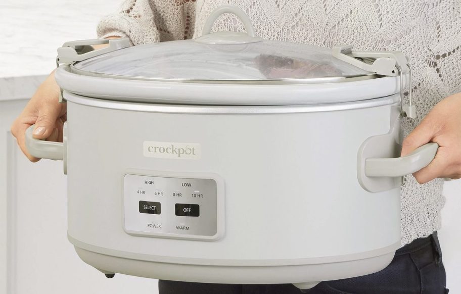 hands holding white crockpot