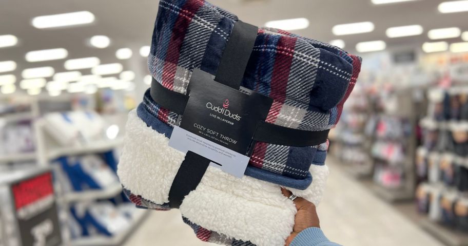 hand holding cuddl duds throw in store