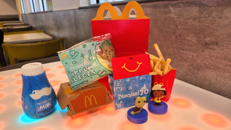 mcdonalds happy meal with disneyland toys displayed on a table
