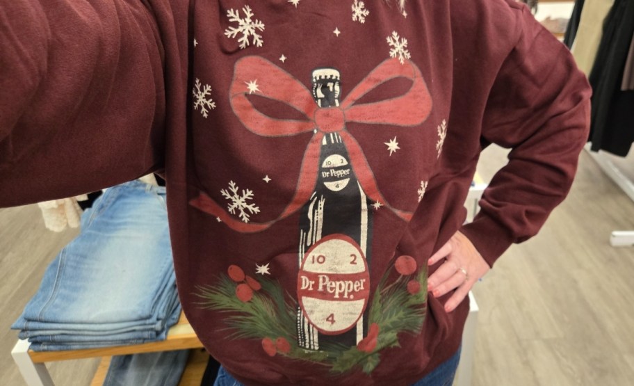 a woman wearing a dr pepper sweatshirt