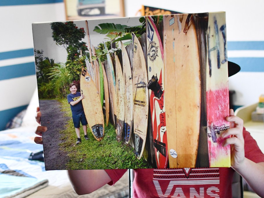 person holding canvas print with kid and surf boards 