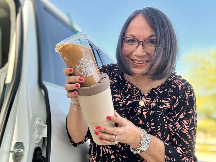 woman holding to go coffee and frost buddy next to van