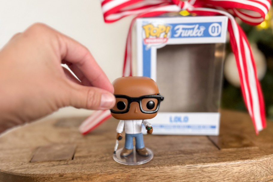 hand putting glasses on funko pop character