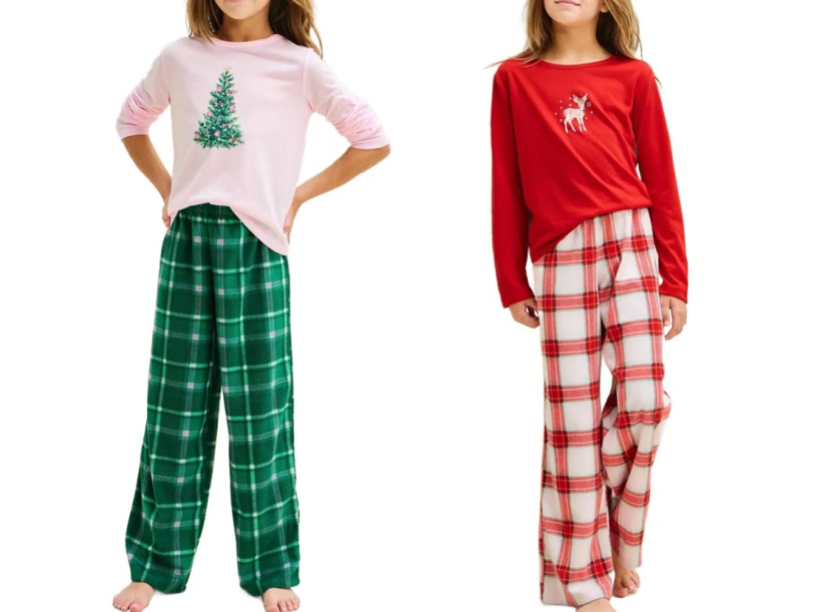 Cat & Jack girls' holiday long-sleeve pajama sets including a light pink shirt with a Christmas tree graphic paired with green plaid pants, and a red shirt with a reindeer graphic paired with white and red plaid pants.