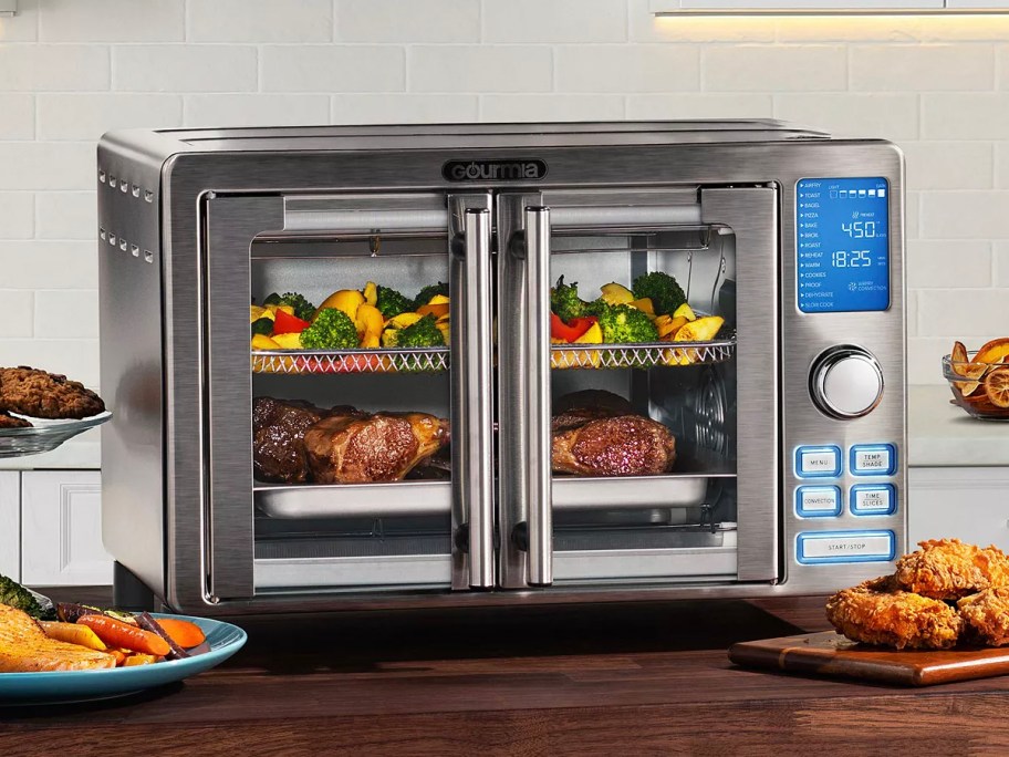 Silver gourmia air fryer oven full of food on the table