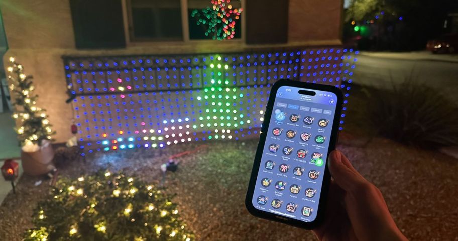 person holding cell phone while controlling govee net lights on house