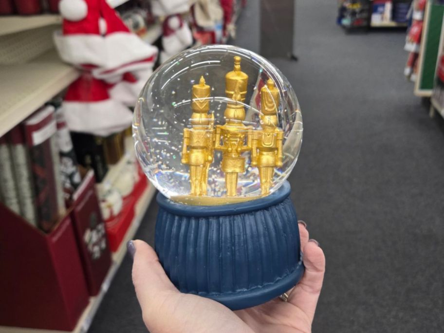 Joyward 5.4" Gold Nutcracker Snow Globe in hand in store