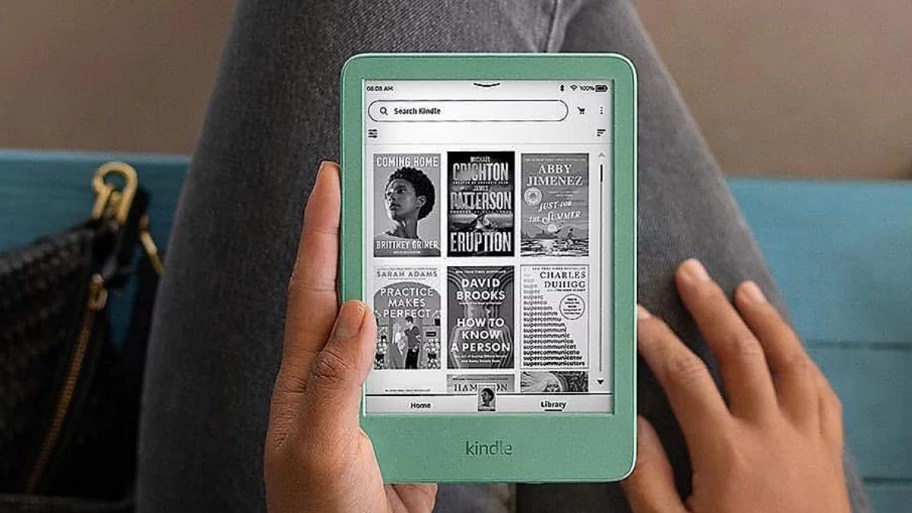 a person holding an amazon kindle in their la